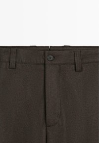 Ciemnobrązowe spodnie o gładkiej fakturze, z zapięciem na guzik, szlufkami na pasek oraz dwoma przednimi kieszeniami. Prosty, klasyczny design.