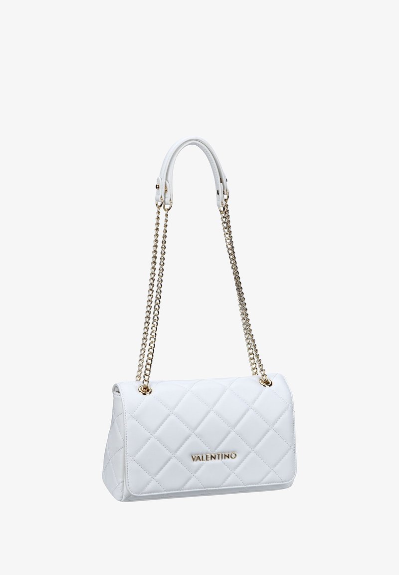 Balta quiltota rokassoma ar zelta ķēdes siksnām un ādas rokturiem. Priekšpusē ir logotips un izteikta, asu malu apdare. Tekstūras materiāls.