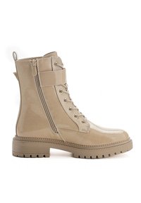 Bottes de combat en cuir verni beige avec un bout rond, un laçage à l'avant, une fermeture éclair sur le côté et des détails texturés sur la tige et la semelle.