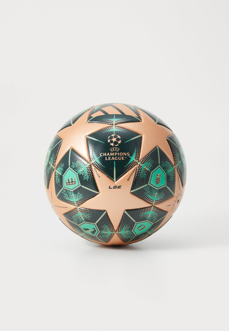 Champions League fotboll med en texturerad, metallisk beige och svart yta med gröna geometriska mönster och stjärnor.