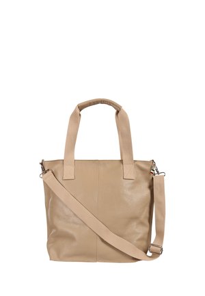 Sac cabas en cuir beige avec deux petites poignées et une longue bandoulière amovible sur fond blanc.