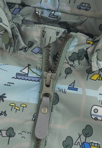 Giacca impermeabile caratterizzata da un tessuto grigio-verde con stampa a tema outdoor, zip YKK e texture morbida. I motivi includono scene di campeggio e veicoli.