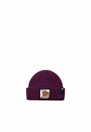 Un bonnet en maille bordeaux à revers, orné d’un écusson représentant un lion avec l’inscription « KING » et d’une petite étiquette noire sur le côté.