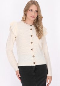 Crèmekleurig brei cardigan met gerimpelde schouderdetails, knoopsluiting en een textuurpatroon. Lange mouwen en een geribbelde zoomafwerking.
