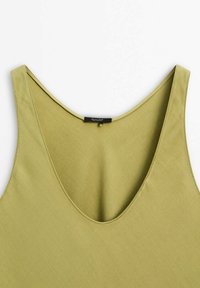 Olivgrünes Tanktop mit tiefem V-Ausschnitt, aus glattem Stoff gefertigt. Verfügt über breite Träger und ein schlichtes, sauberes Design ohne Muster.