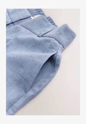 Hele sinised teksapüksid, millel on tekstuuriga viimistlus, küljetaskud ja mugavust parandav elastne vöökoht. On nähtavad detailne õmblus.