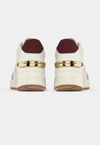 Baskets blanches avec des accents bordeaux et un détail métallique doré sur le talon. Elles présentent une tige texturée et une semelle plateforme avec une semelle extérieure en caoutchouc marron.