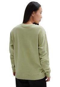 Sudadera de algodón verde con mangas largas, cuello redondo y puños de canalé. Textura suave con un ajuste relajado. Sin detalles visibles en el frente.