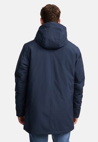 Marineblå hættejakke med en glat, mat overflade. Midt-lår længde med en afslappet pasform og minimalistic design.