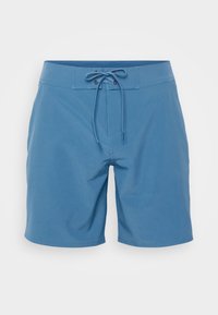 Blaue Badeshorts mit verstellbarem Bund, leichtem Gewebe und geradem Schnitt. Sanfte Textur mit minimalen Nähdetails.