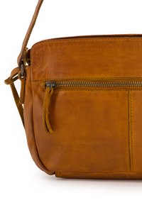 Braune Leder-Crossbody-Tasche mit einem Reißverschlussfach, das eine weiche Textur und Steppdetails aufweist, ergänzt durch einen Schulterriemen.