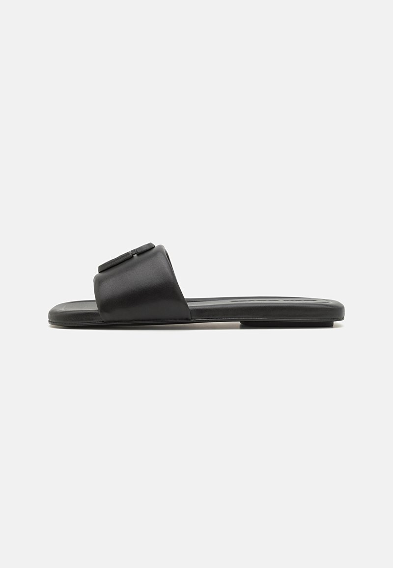 Zwarte instapsandalen van glad leer, met een brede band, een vlak ontwerp en een gereinigde binnenzool. Minimalistische stijl, open teen.