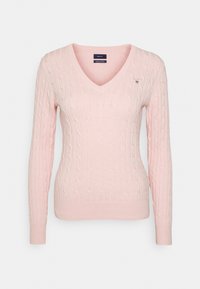 Pullover rosa a maglia rasata con scollatura a V, maniche lunghe, polsini e orlo a costine. Presenta un piccolo logo sul lato sinistro del petto. Realizzato in cotone.