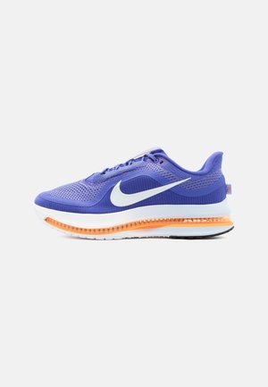 Baskets Nike Air Zoom violettes avec logo swoosh blanc, semelle orange amortie par air et empeigne en mesh pour la respirabilité, présentées de profil.