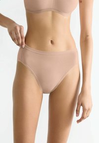 Beige Bikini-Brief aus weichem, elastischem Stoff. Mit nahtlosem Bund und moderatem Schnitt. Glatte Textur, minimale Details.