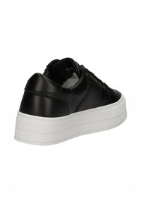Sneaker sintetico nero con punta arrotondata e slanciata, suola piatta bianca rialzata e lacci neri. Materiale liscio con dettagli minimi.