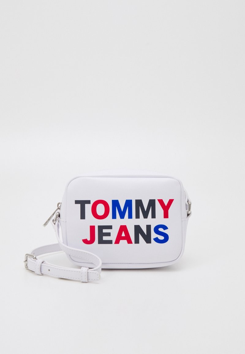 White rectangular crossbody bag with "TOMMY" in red and "JEANS" in blue and black, featuring a zipper and adjustable strap.