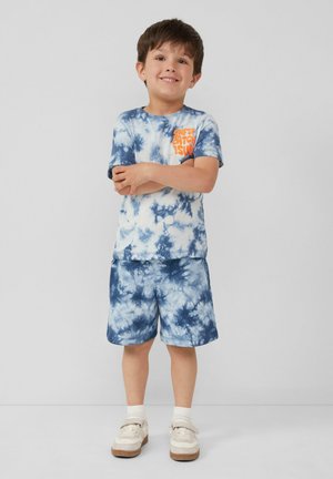 Kinderen tie-dye outfit met een blauw-witte T-shirt met korte mouwen, voorzien van een oranje graphic, en bijpassende blauwe shorts. Gemaakt van textuurrijk katoen.