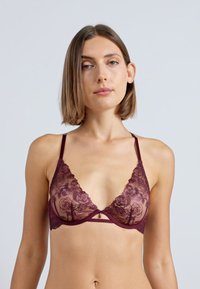 Burgundi csipke bralette virágmintákkal, áttetsző kosarakkal, állítható pántokkal és középen elhelyezett díszítéssel a további részletekért.
