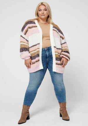 Cardigan en tricot épais aux rayures pastel de rose, blanc, marron et crème. Ouvert sur le devant avec des poignets et un ourlet côtelés, associé à un jean ajusté.