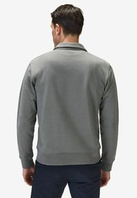 Grå sweatshirt med en slät textur, med en enkel design, ribbade muddar och krage. Visad bakifrån, som framhäver rena linjer.