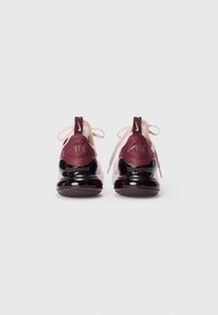 Nike Air tenisice s gornjim dijelom u boji bordo i ružičastoj. Imaju sjajnu crnu petu, okrugle vezice i "AIR" oznaku na stražnjem dijelu. Ukupno meka tekstura.