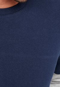 Camiseta de algodón azul marino con cuello redondo y mangas cortas, textura suave y detalles de costura mínimos.