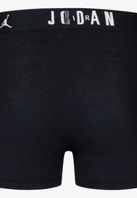Boxer neri in tessuto liscio ed elastico. Presentano una fascia in vita bianca con la scritta "JORDAN" e un piccolo logo sul lato.