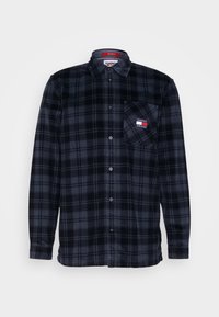Camicia a scacchi nera e grigia scura con colletto e taschino sul petto, con patch del logo Tommy Jeans.