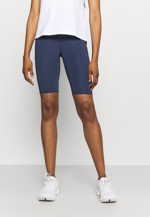 Mørkeblå cykelshorts lavet af strækbart stof, designet til at sidde tæt, med syninger langs sømmene for holdbarhed.