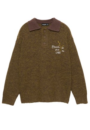 Brauner, gestrickter Pullover mit kontrastierendem Kragen, drei Knöpfen und sticktem Schriftzug „Blooming with Care“. Der Schriftzug ist mit einem Blumenmotiv versehen.