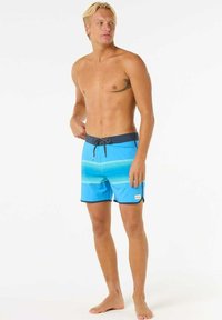 Pantaloni da surf blu con un design gradient, dotati di una vita scura e di un cordino, realizzati in materiale leggero e a rapida asciugatura.
