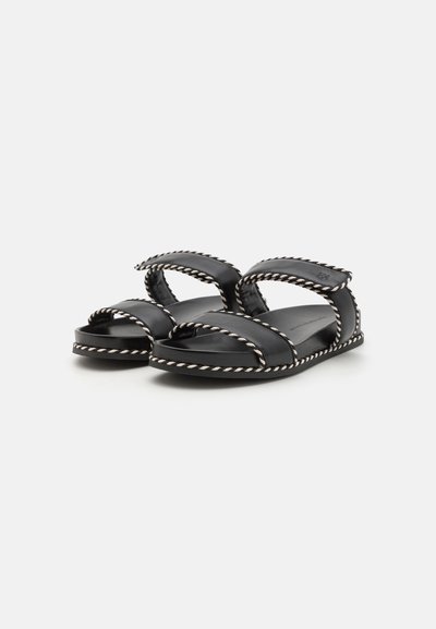 Black leather sandals with crossover straps, accented by a braided white trim on the edges and a flat sole. Simple and functional design.