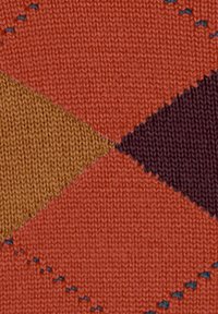 Gebreide stof met een geometrisch ruitpatroon in oranje, bruin, mosterd en donker paars. Zachte textuur met zichtbaar stikwerk.