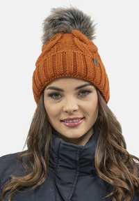 Strikket orange hue med et chunky mønster og en stor faux fur pom-pom øverst; har en lille læderlogo-patch.