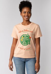 Perzikkleurig katoenen t-shirt met een grafisch ontwerp van ramen in een kom, met groene eetstokjes, en de tekst "Het leven is beter met een kom ramen."