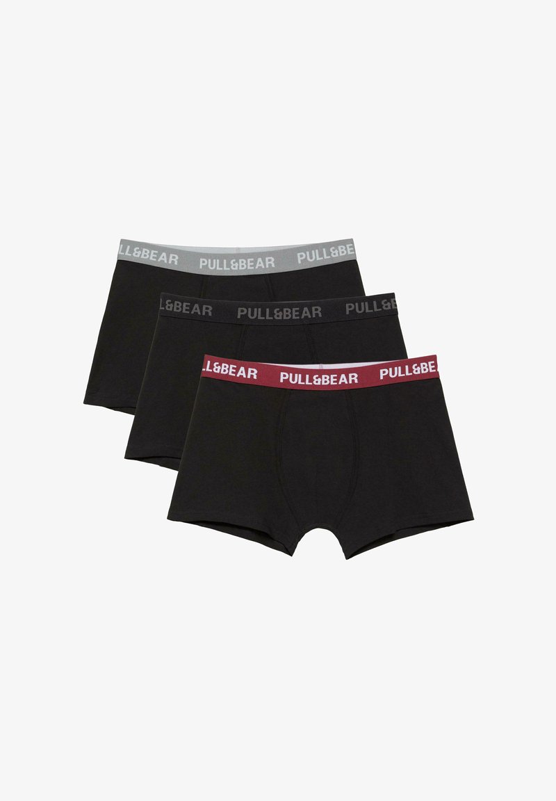 Trois boxers noirs avec ceintures élastiques en gris, noir et bordeaux, chacun marqué du texte "PULL&BEAR".