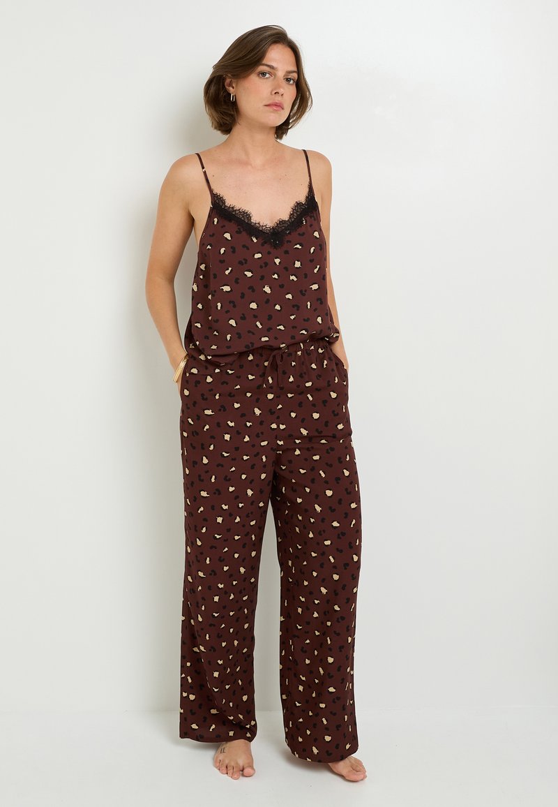 Ensemble de pyjama à motif léopard marron avec des finitions en dentelle noire, comprenant un débardeur ample et un pantalon à jambes larges avec une taille élastique et des poches latérales.