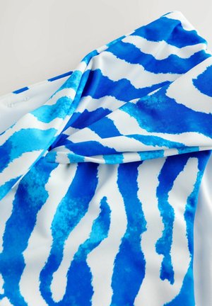 Blau-weißer Stoff mit wasserähnlichen Streifen. Glatte Textur, zeigt Blautöne in unterschiedlichen Intensitäten auf einem weißen Hintergrund.