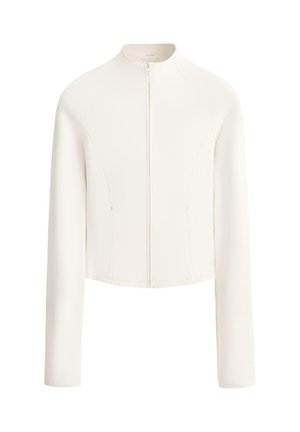 Jakna v krem barvi z dolgimi rokavi, z zadrgo spredaj in minimalnimi šivi, z okroglim izrezom.