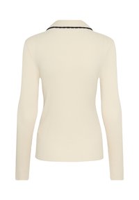 Kremno obarvan pulover z rebrasto teksturo in dolgimi rokavi, z črnimi detajli ob hrbtni ovratnici, prikazan s hrbtne strani.