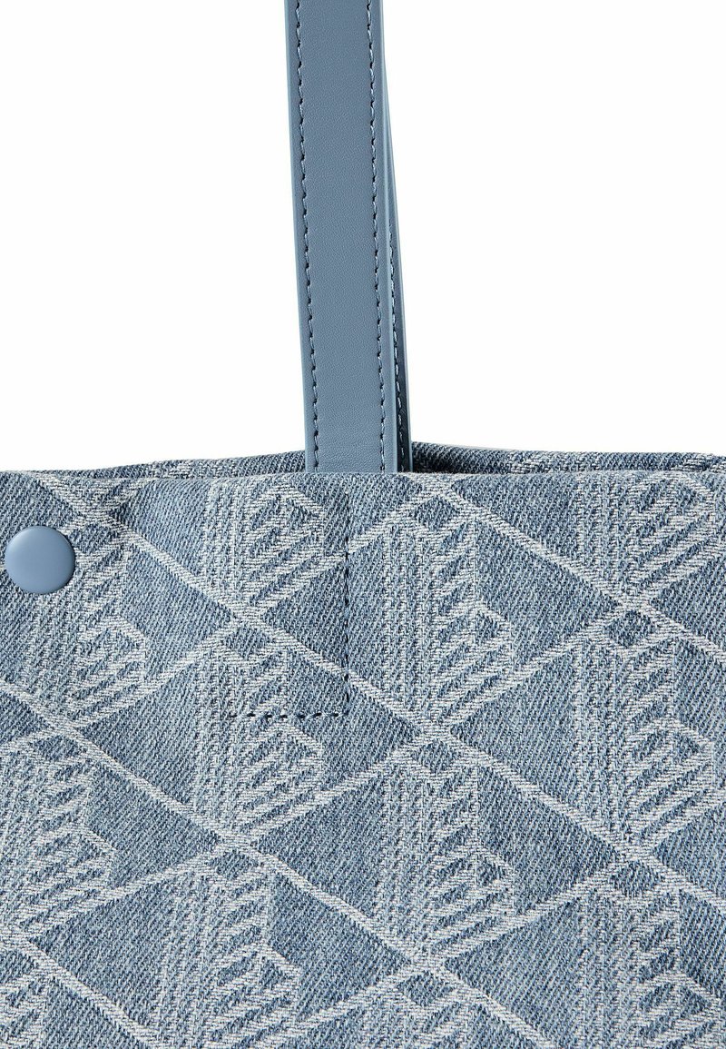 Borsa tote in tessuto blu con motivo geometrico bianco a diamante, bottone a pressione blu e manico in pelle blu cucito.