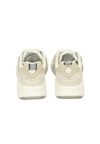 Beige athletic sneakers with a textured suede and mesh upper, featuring a striped accent on the heel and a thick white sole.