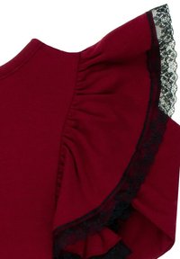 Bordowa bluzka z falbaniastym rękawem, ozdobiona czarną koronkową lamówką wzdłuż krawędzi. Wykonana z miękkiego materiału o gładkiej fakturze.