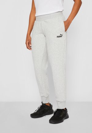 Gai pelēki sporta bikses ar ribotām piedurknēm, elastīgu jostu un melnu Puma logo kreisajā augšstilbā, apvienotas ar melniem sporta apaviem.