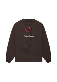Brązowy sweter z dzianiny z grafiką narciarza w różu i czerni oraz napisem "Cabin Couture". Golf i mankiety ściągane, luźny krój.