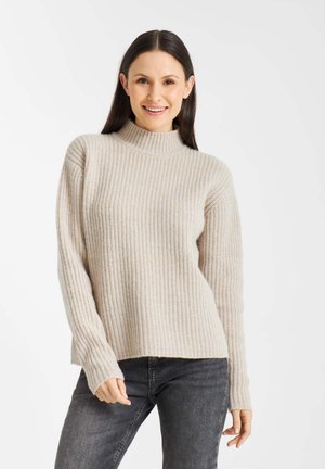 Beige geribbelde gebreide trui met een hoge hals, lange mouwen en een relaxed fit. Gelaagd stof met subtiele kleurvariaties.