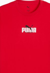 Rød bomulds T-shirt med et hvidt "PUMA" logo og en sort silhuet af en puma ovenfor. Korte ærmer og rund halsudskæring.