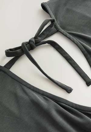 Top bikini grigio a coste con chiusura a nodo e spalline sottili. Il tessuto ha una texture liscia e un design minimalista.