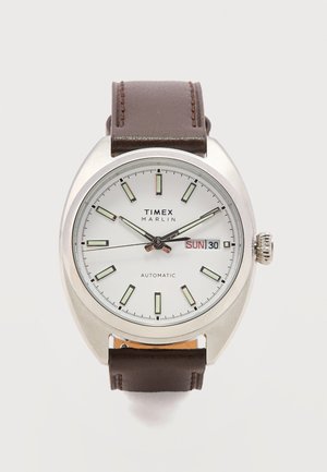 Timex Marlin automatisch polshorloge met een witte wijzerplaat, luminescente markeringen, dag- en datumweergave die zondag de 30e toont, en een bruine leren band.